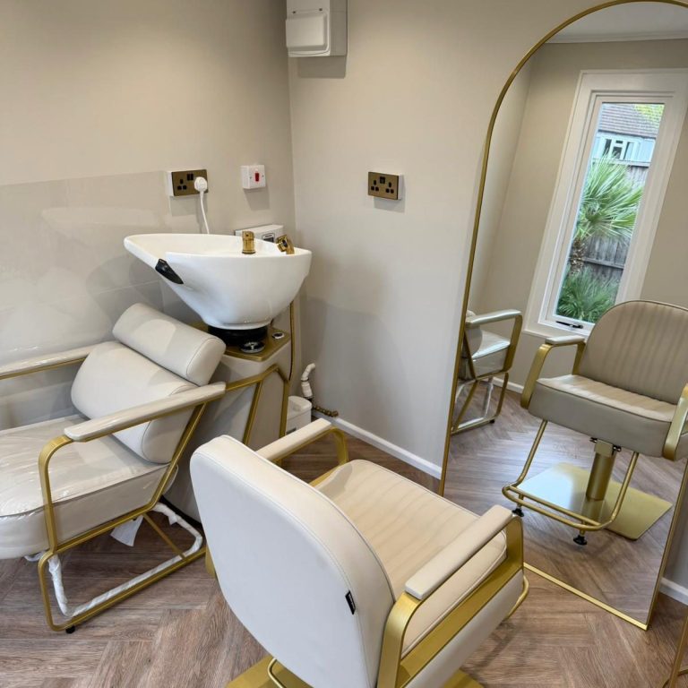 A person using a hairdryer and round brush on another person's hair.